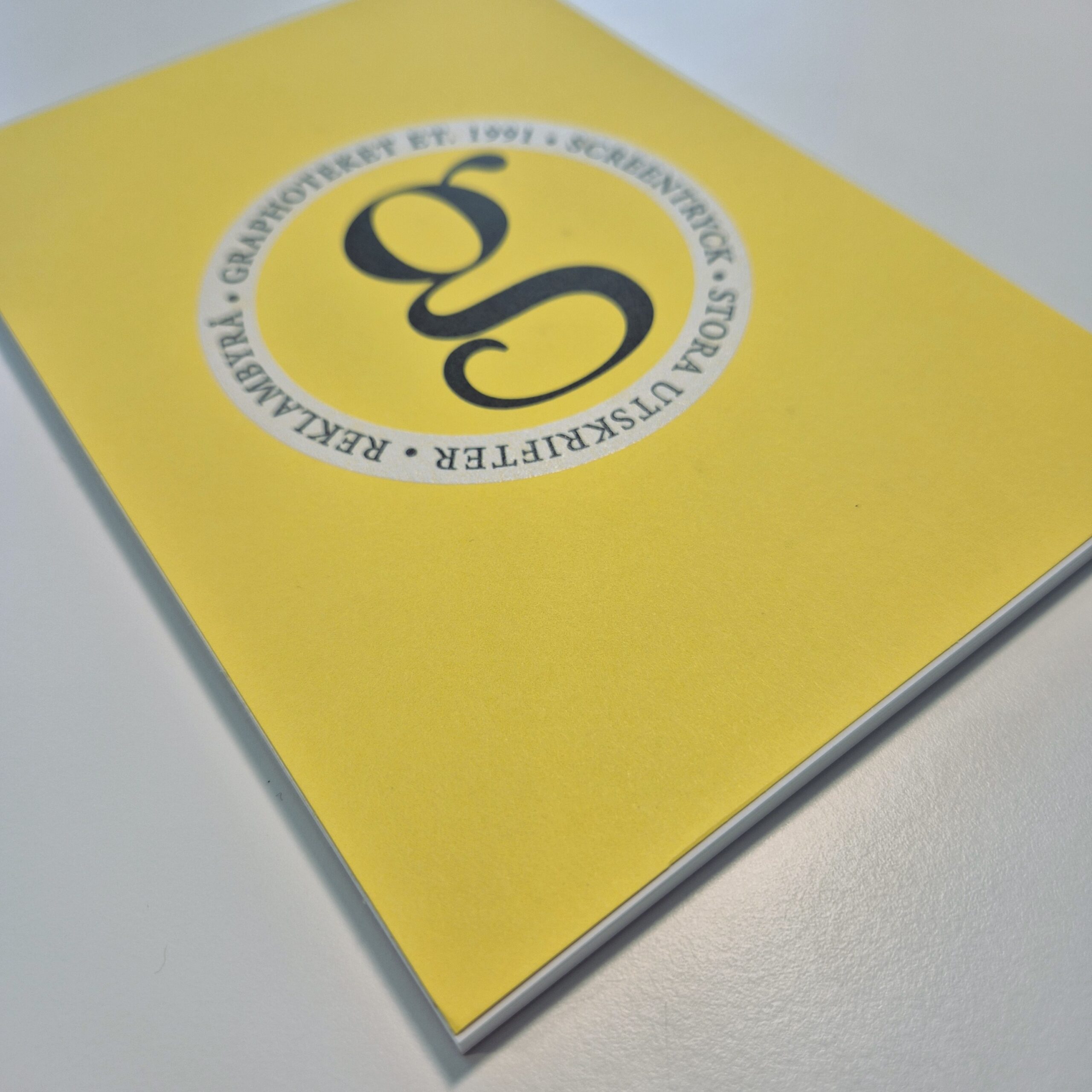 Limmat block med graphotekets logo på gult omslagspapper, digitaltryck